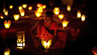 A young novice sets down a lantern in the temple