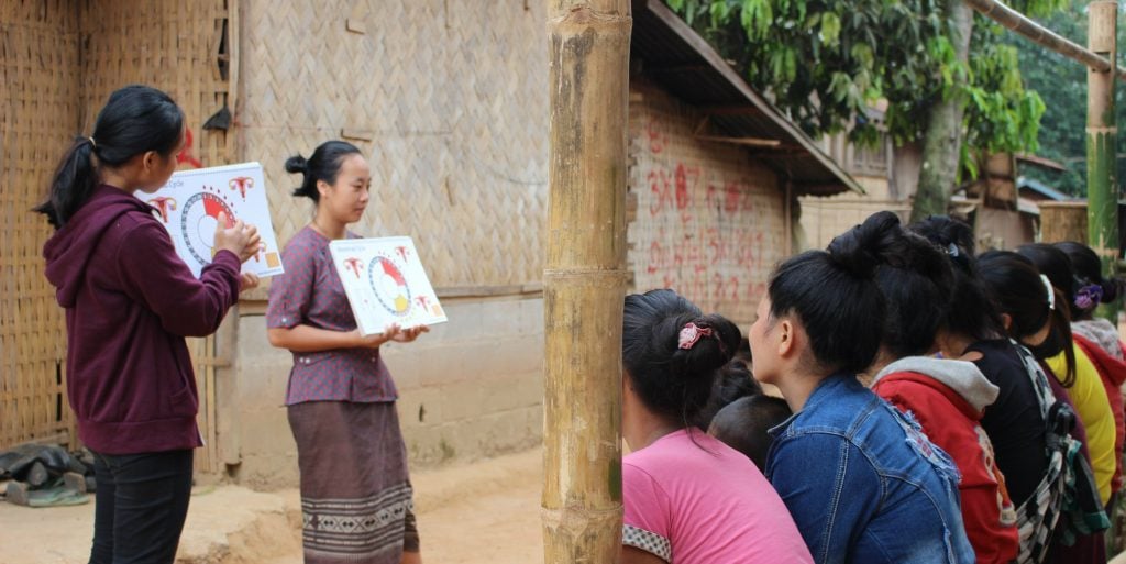 Two local women from Laos conduct a menstrual health workshop in a rural village.