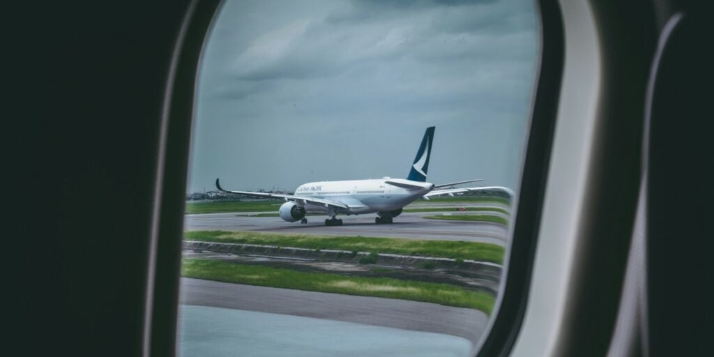 Image taken from the window seat of a plane of a plane taking off on the runway.