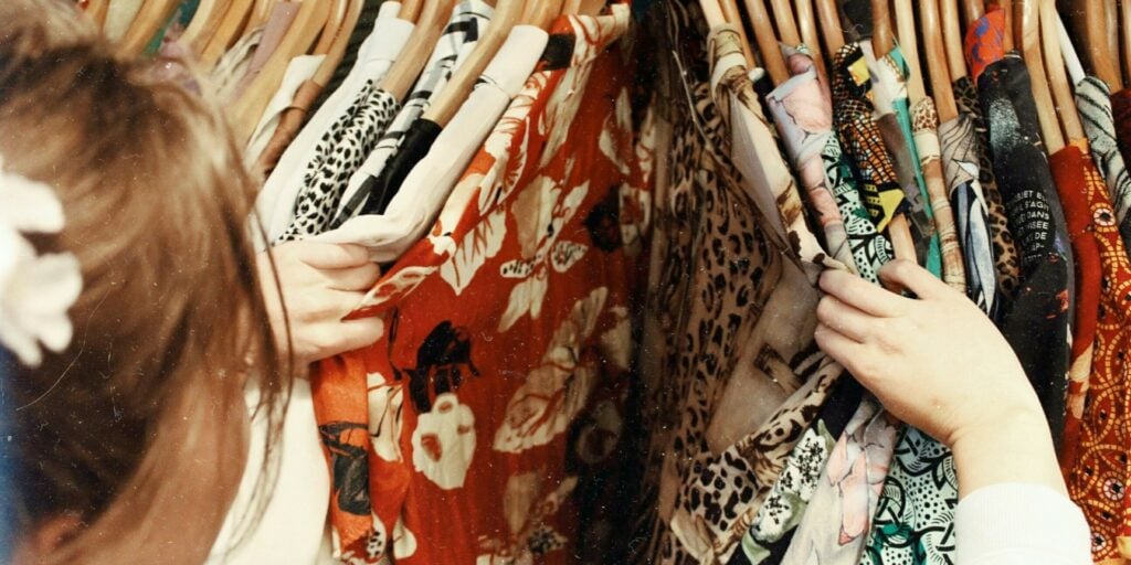 Woman thrifting through dresses on a hanger