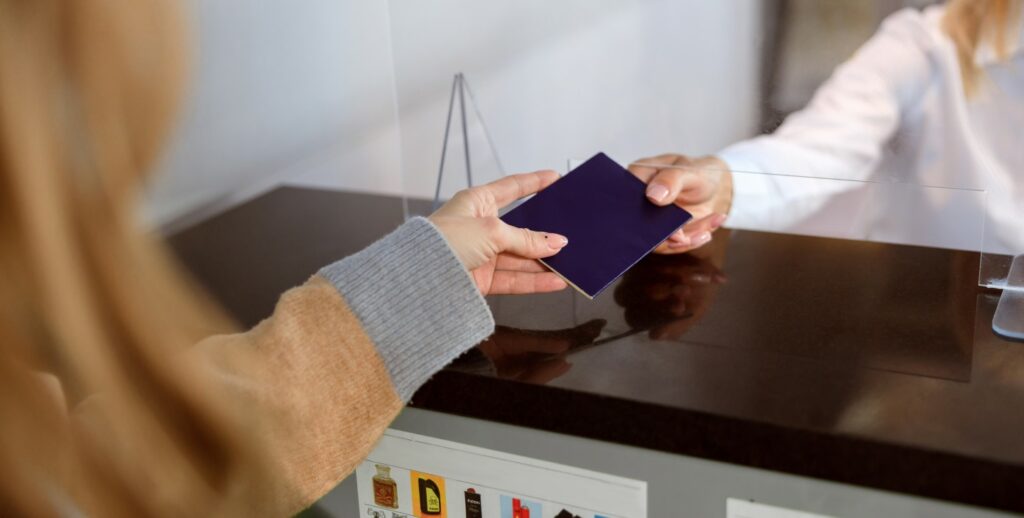 Woman handing over her passport at passport control at the airport