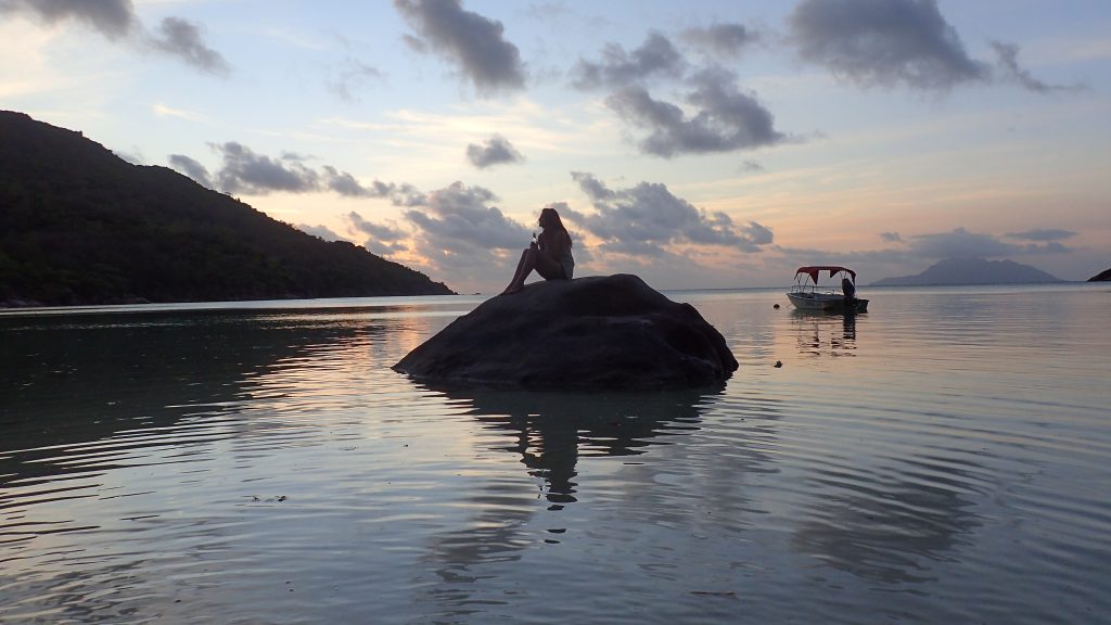 woman sitting on a rock in the ocean