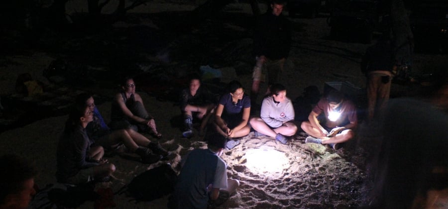 conservationists sitting around camp light