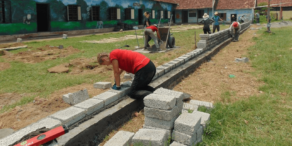 GVI teen volunteers in India work on a construction project carry out an expansion project at a local school.
