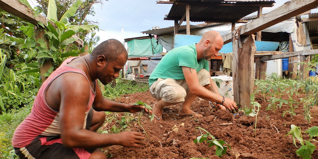 Two men working in a garden together.