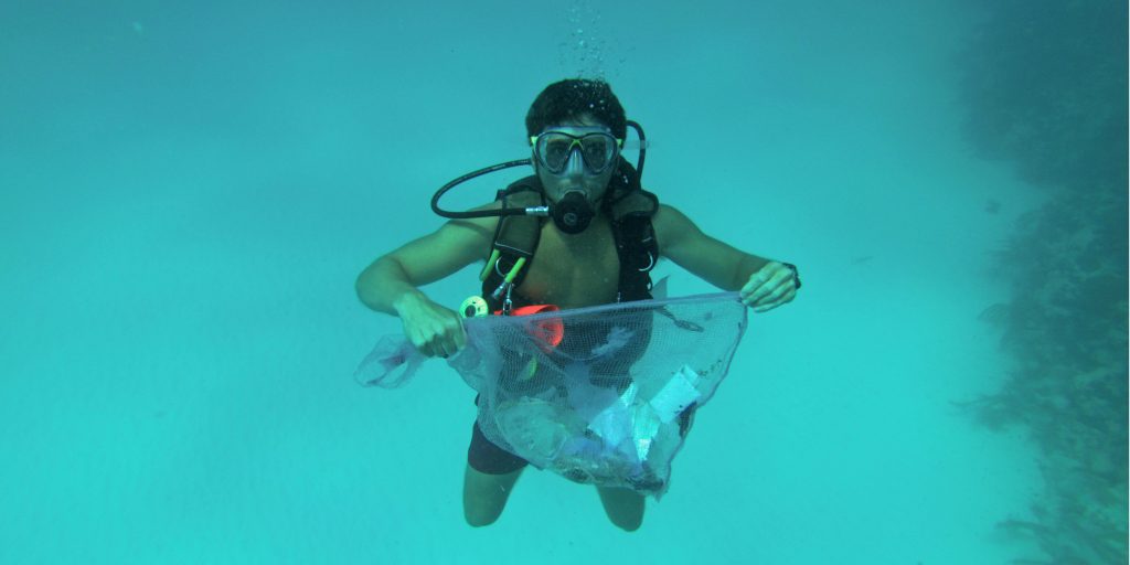 Plastic pollution endangers marine life. Here, a GVI volunteer helps clean up the ocean floor during a dive against debris, in Mexico.