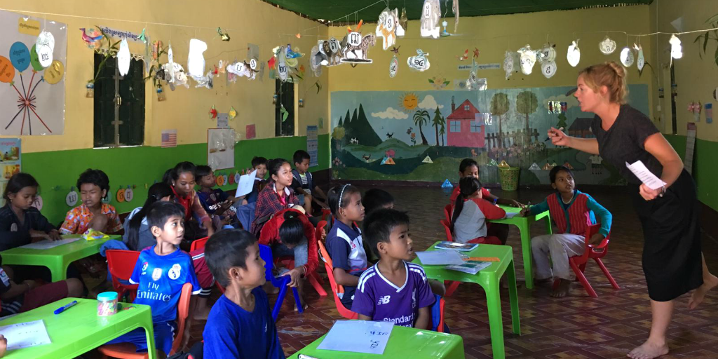 A volunteer teacher teaching a class of young children in Cambodia