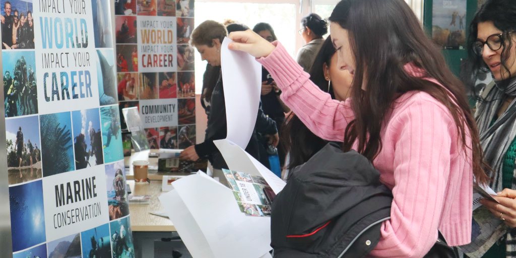 A prospective volunteer perusing program information at a GVI stand.