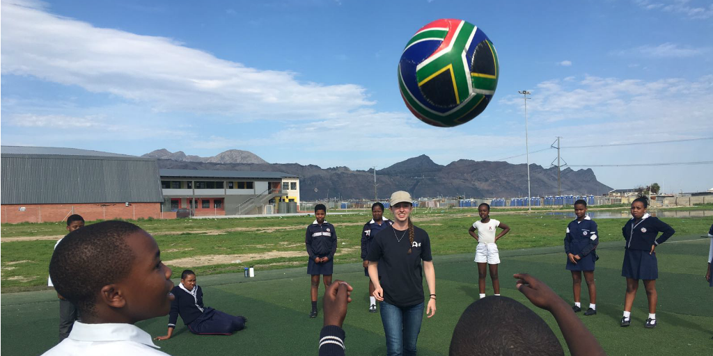 A volunteer facilitating a soccer lesson with children in South Africa.