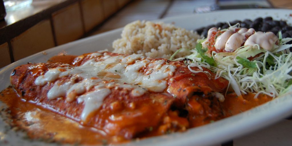 An enchilada is a corn tortilla rolled around a filling and covered with a sauce.