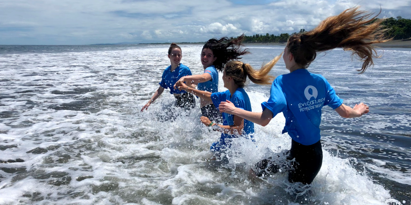 Under 18 participants splash through waves in Costa Rica. 