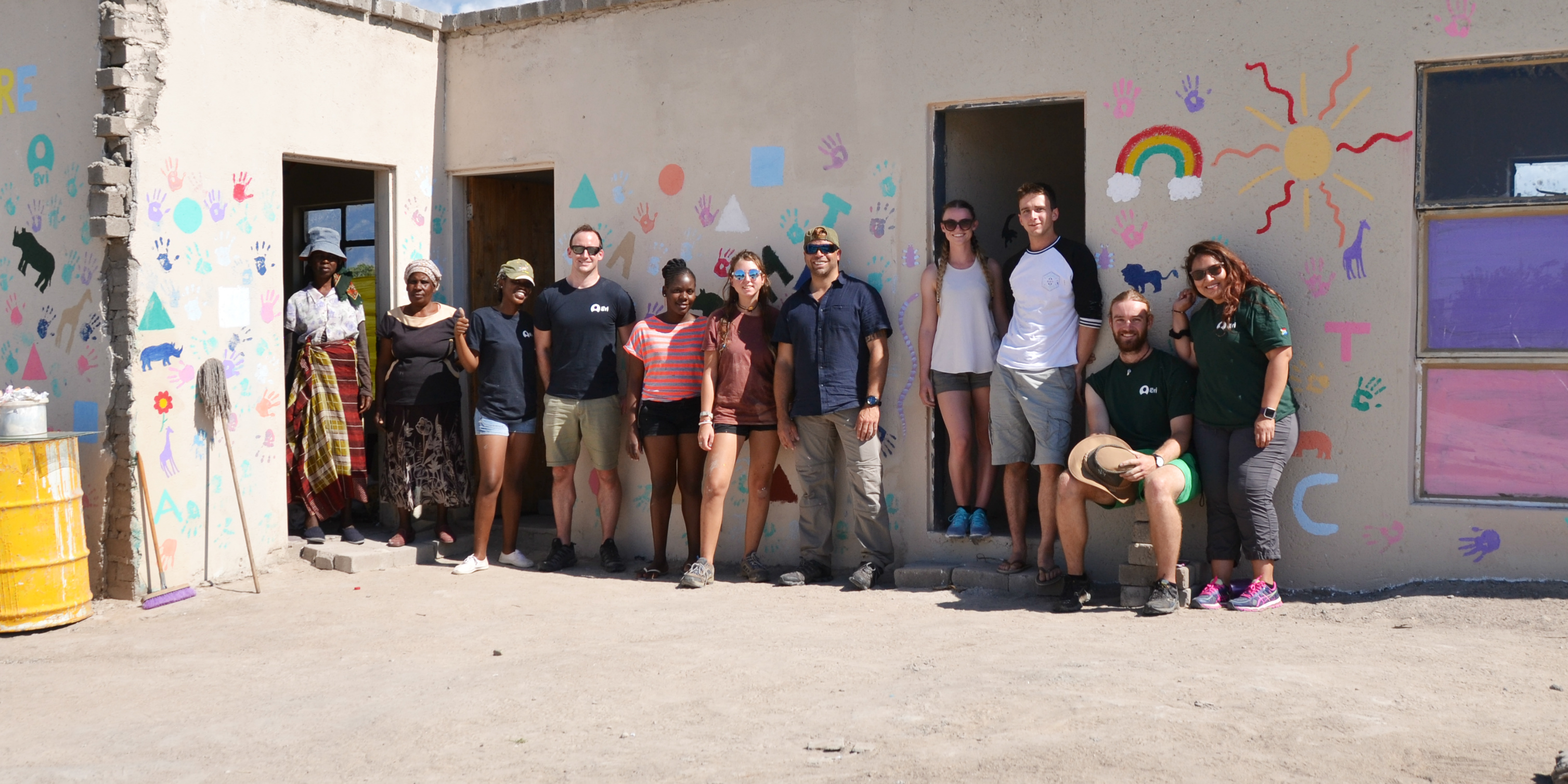 While volunteering in Africa with animals, GVI participants took time from their research to improve facilities at a local creche. Pictured: GVI participants and creche owners stand in front of the finished kitchen.