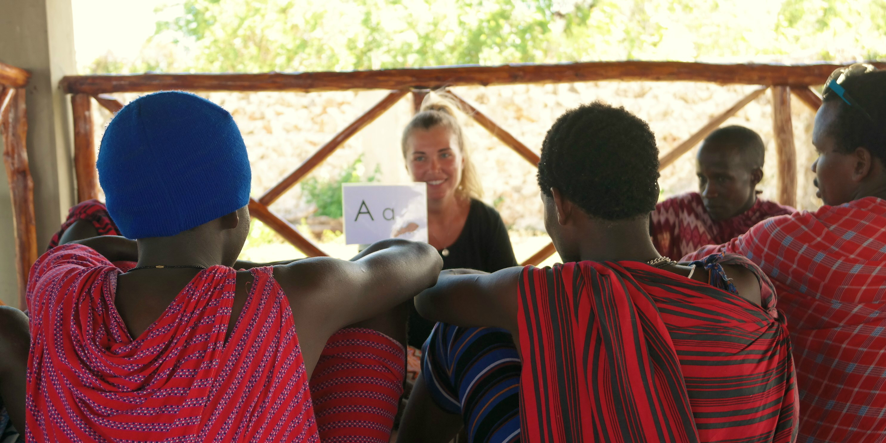 A volunteer teaching in Tanzania works with Masaai people on their English.