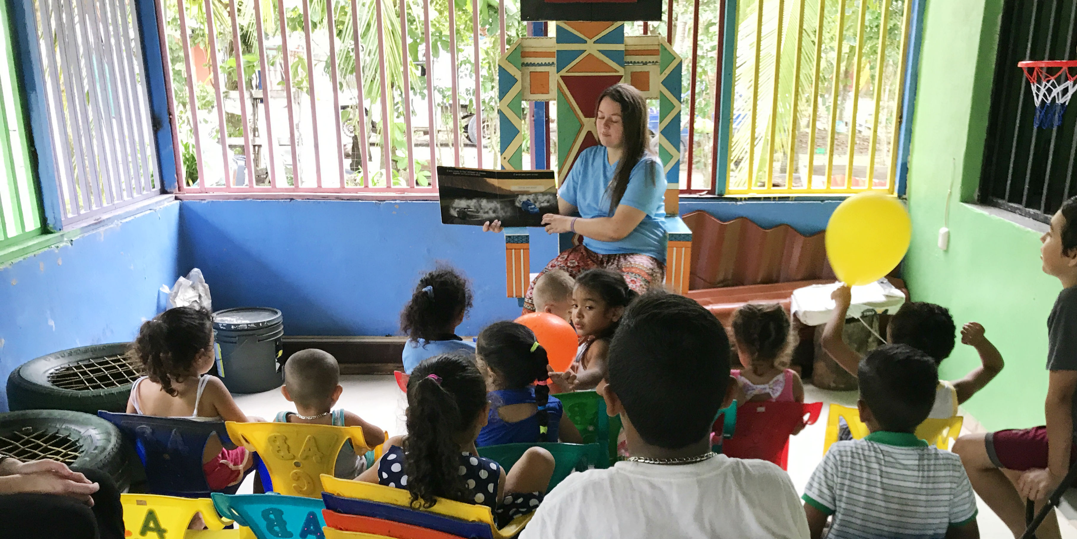 A GVI participant reads to learners in Quepos, Costa Rica. Teaching experience is one of the many gap year benefits.
