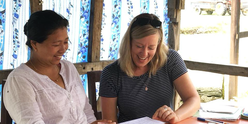 A GVI participants works on English language skills with a woman in Laos. This is one of many kinds of career break work abroad.