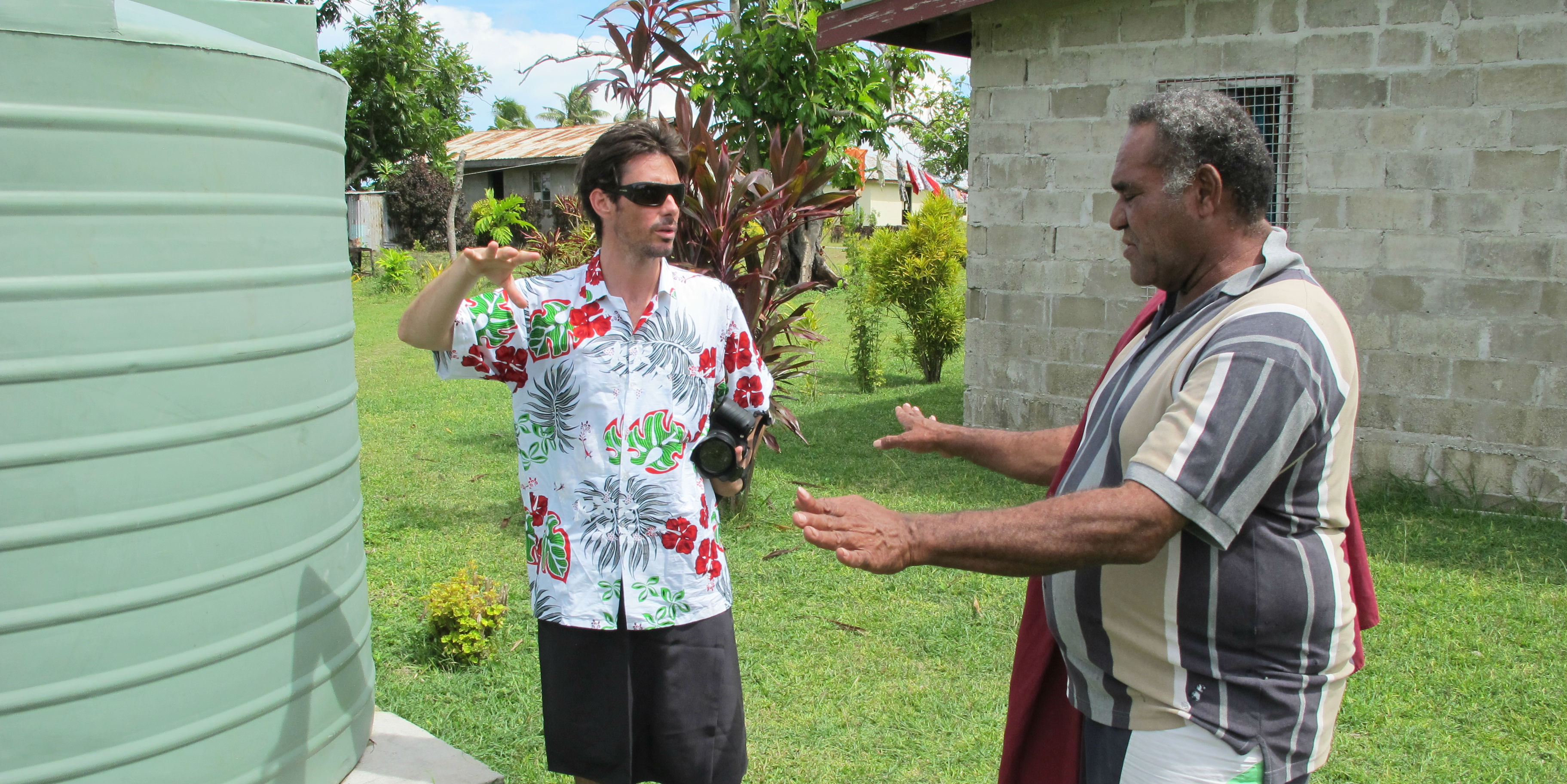 A GVI participant engages with a community member about a water tank, in Fiji. Working on water security is one of the best things you can do as an adult volunteer. 
