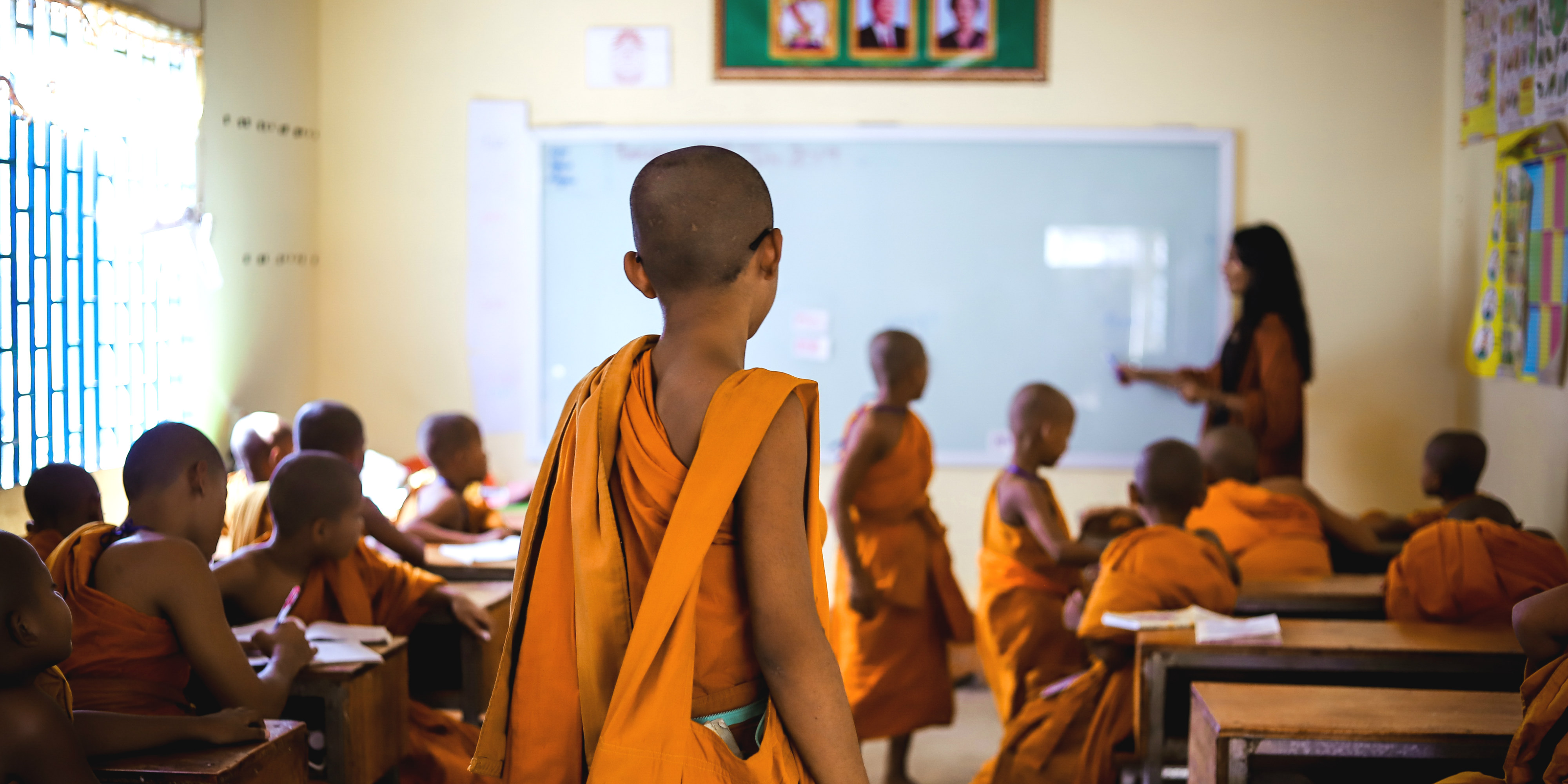 A novice monk enters an English lesson in Cambodia. This program, which is one of the best volunteer abroad programs for adults, seeks to increase educational capacity in Kampong Cham.