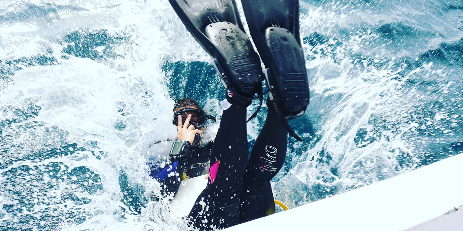 While working toward their PADI certification, this diver enters into the waters surrounding Mahe Island.