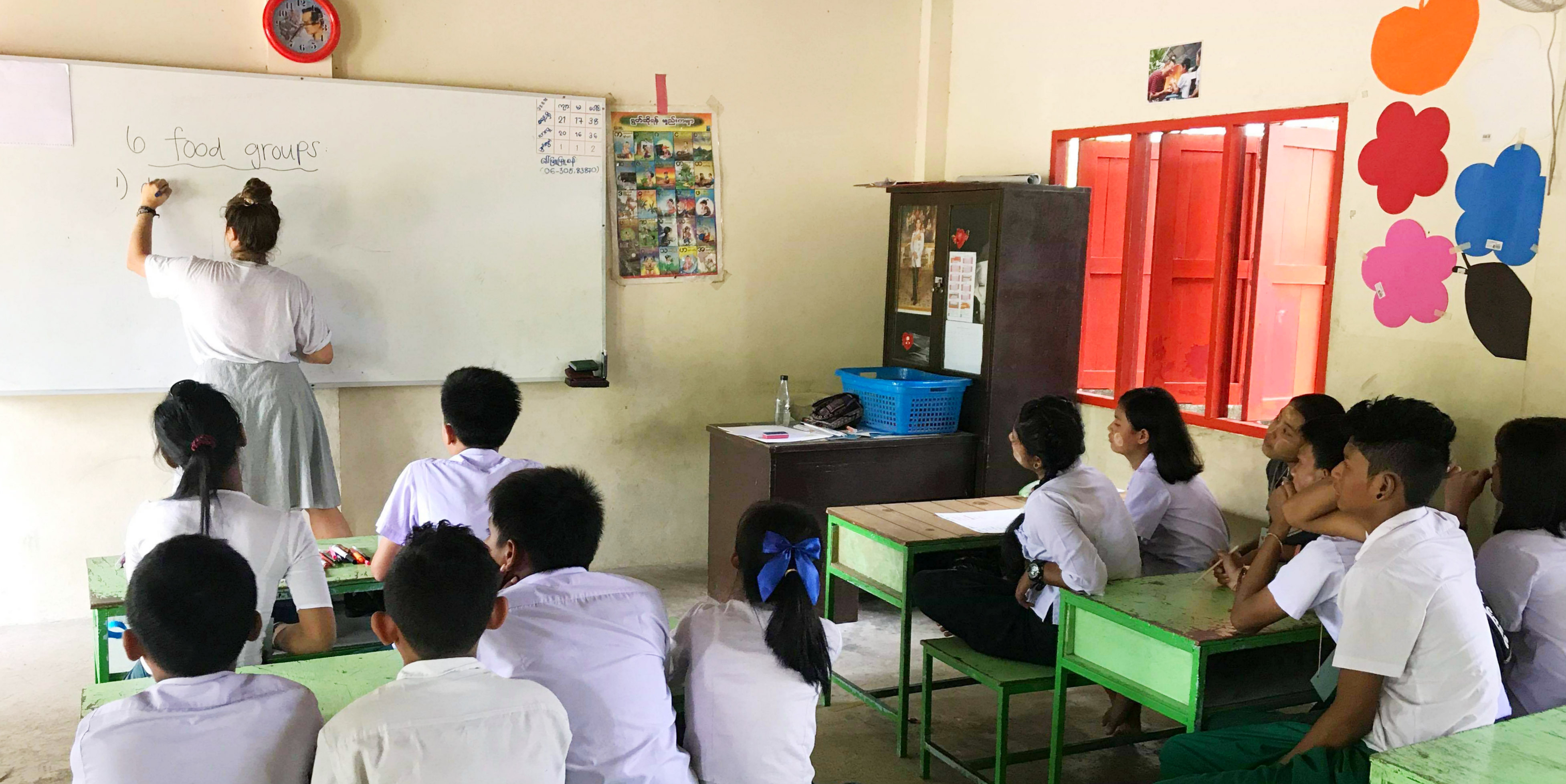 A teach English in Thailand participant explains the different food groups to a class of learners. 