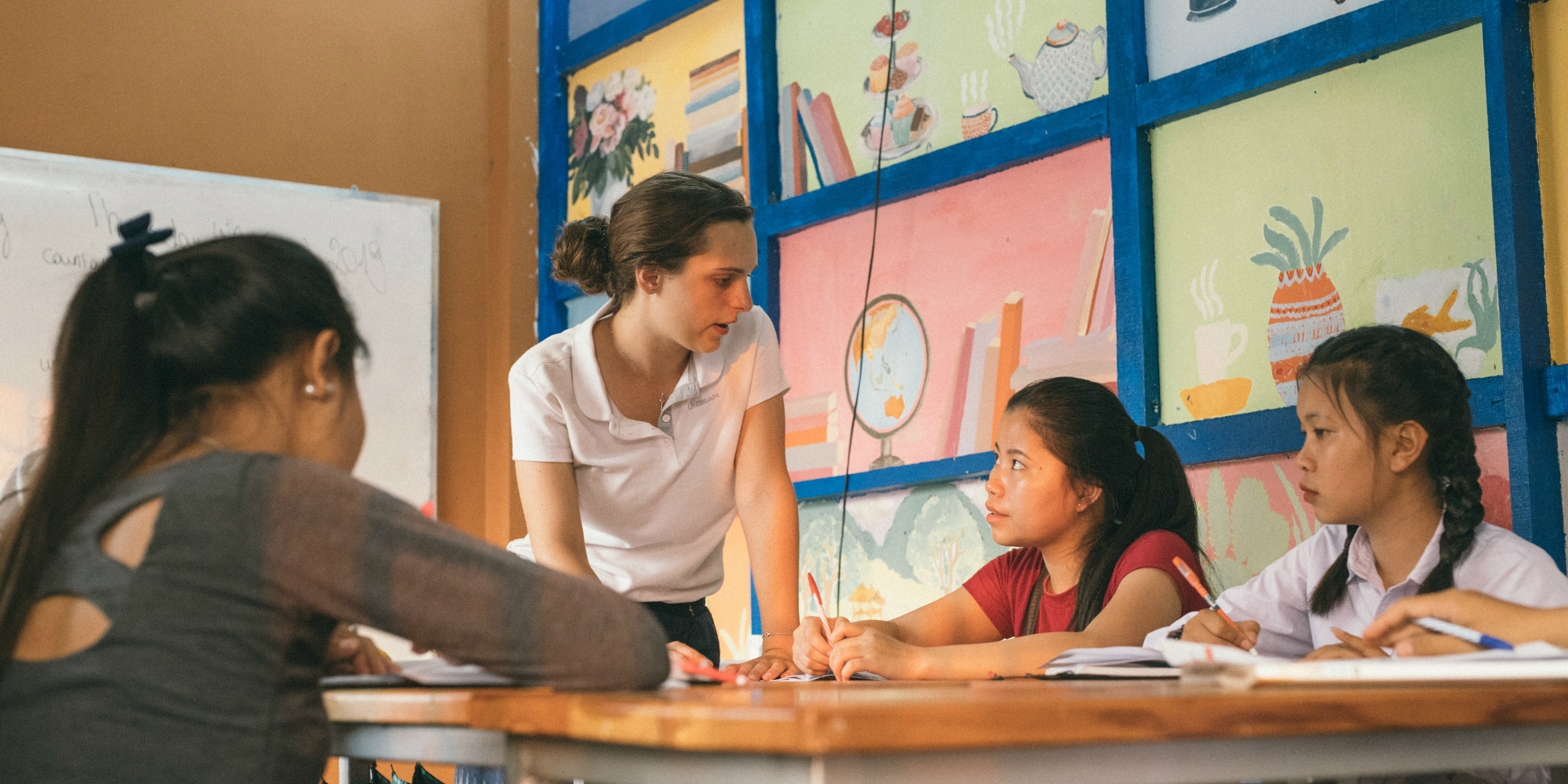 A GVI participant engages with women learners while on a volunteer teaching program.