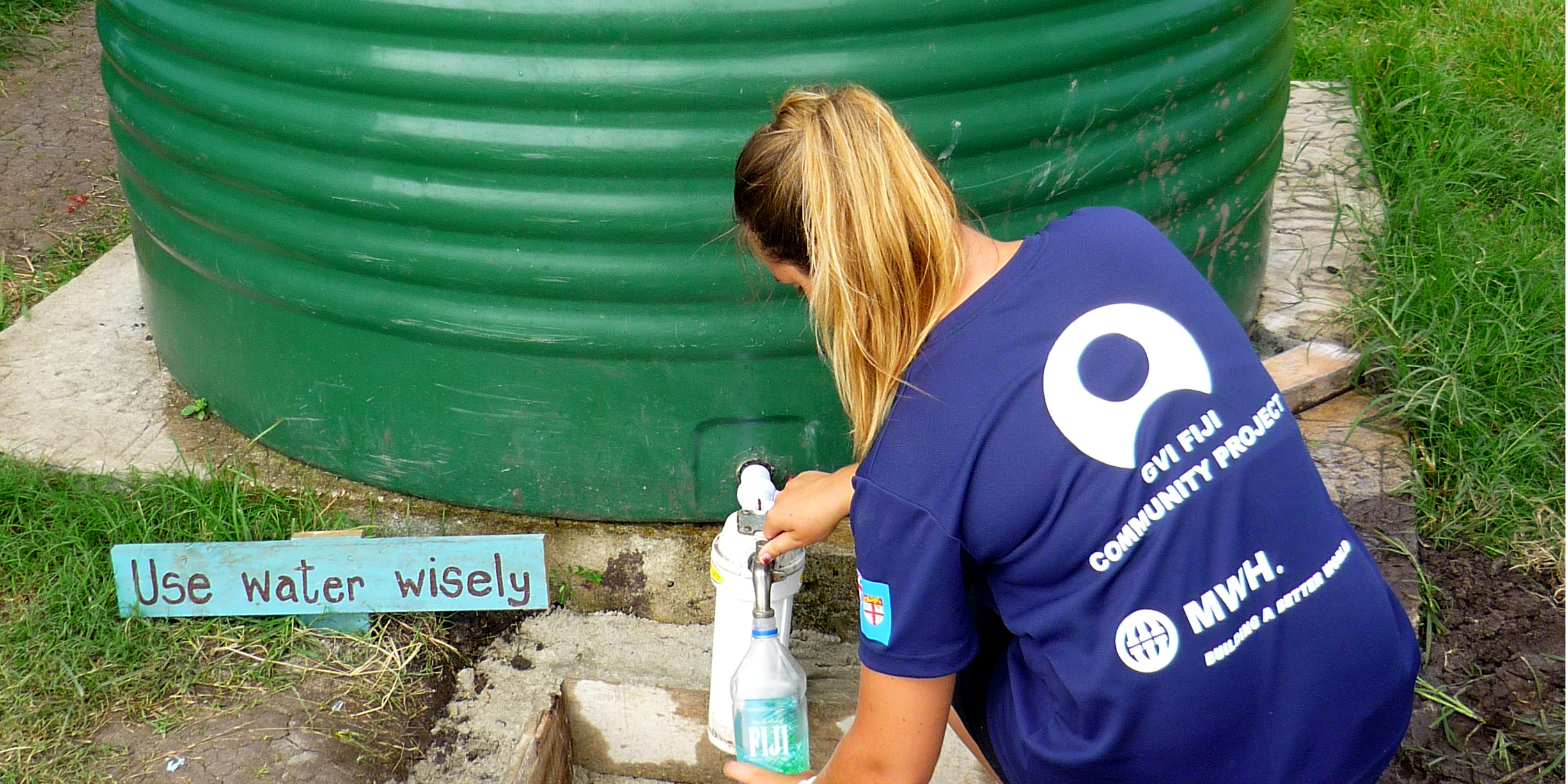 A participant collects water from a rainwater collection point in Dawasamu, Fiji as part of their community development internship.