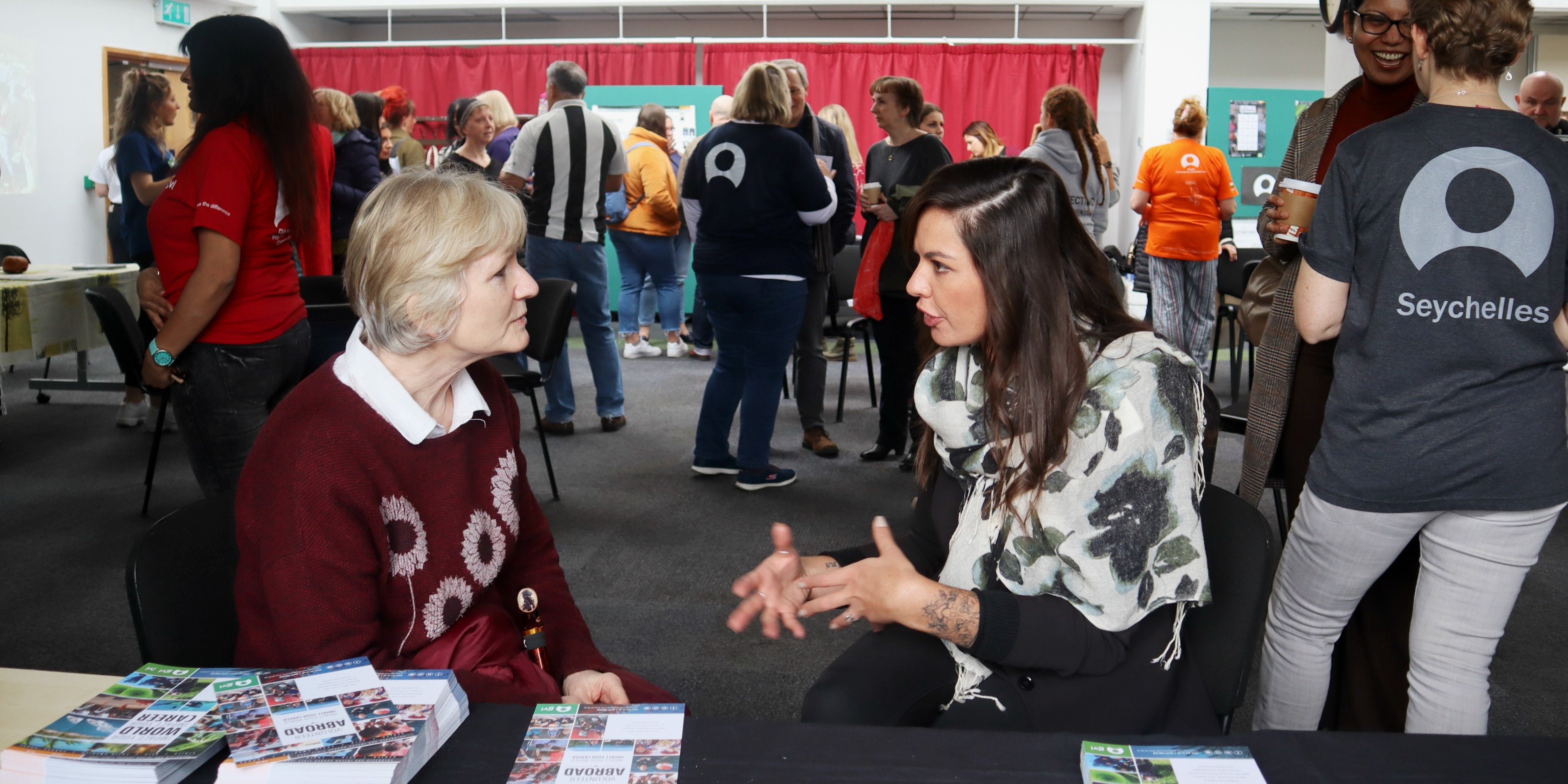 A GVI staff member chats to a parent about the many teen volunteering opportunities with GVI, at an Open Day in London. 