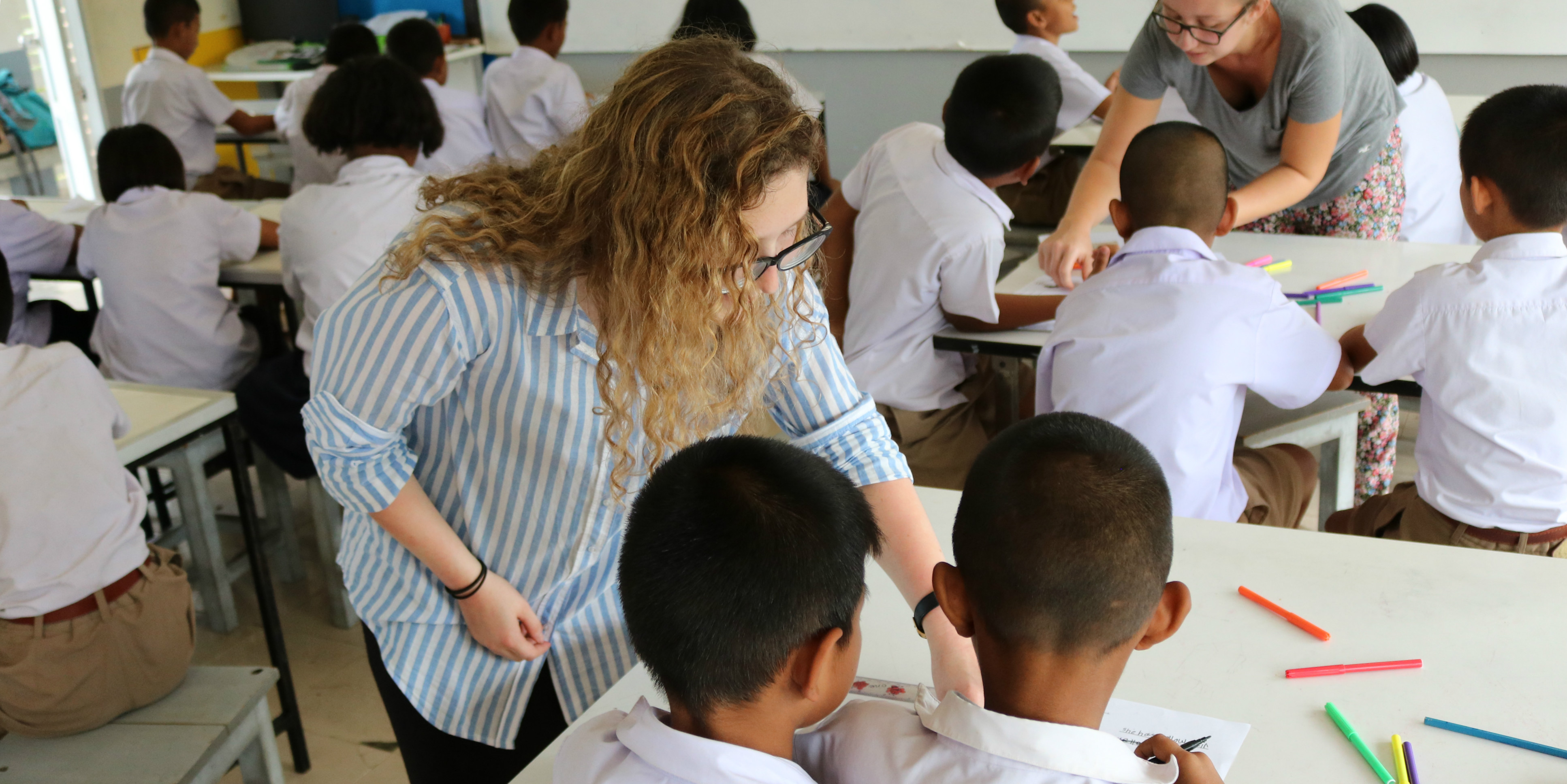 After completing their TEFL training with GVI, a participant assists learners in a school in Thailand.
