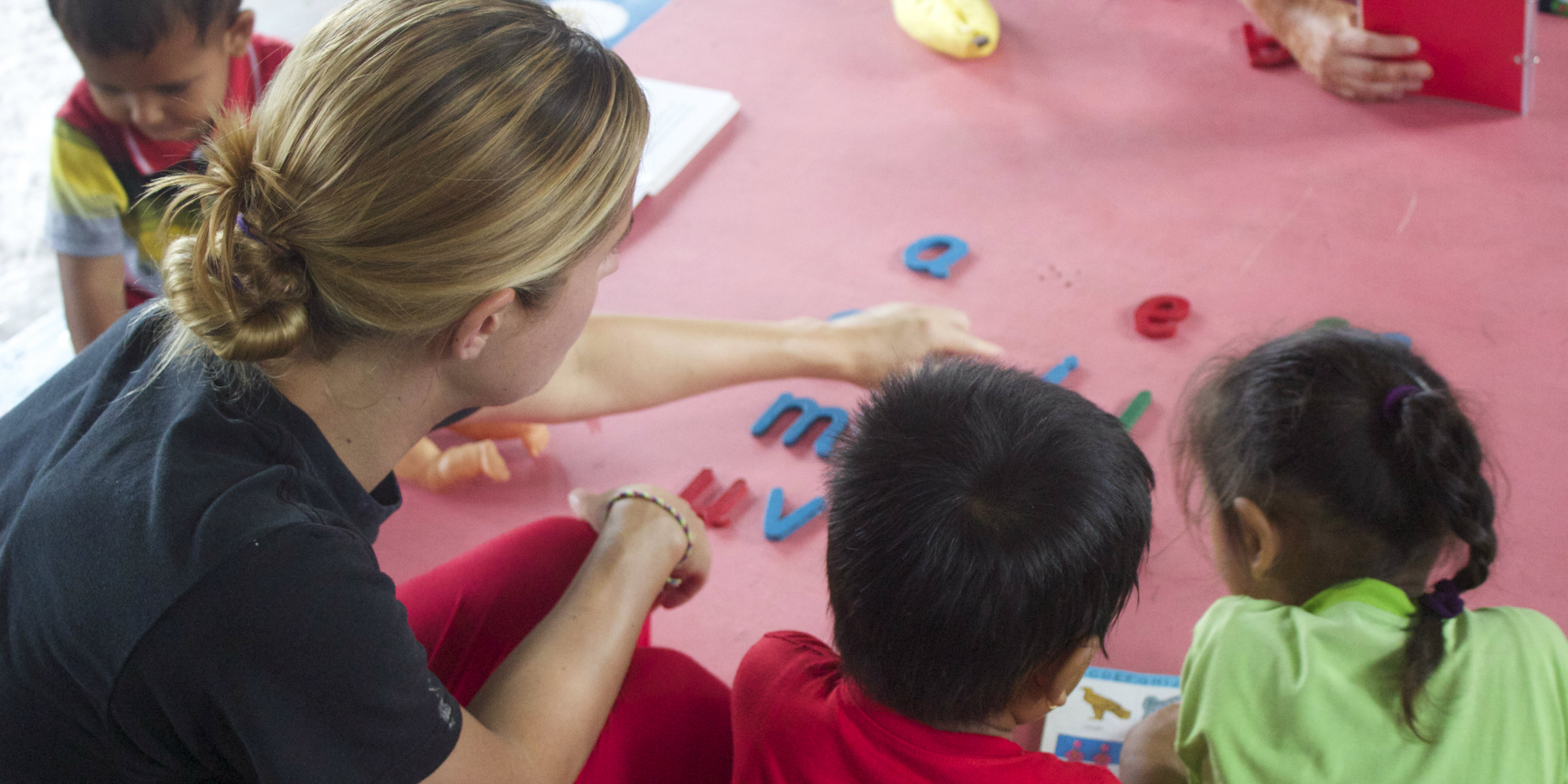 A TEFL teacher plays a word game with learners on a GVI program.