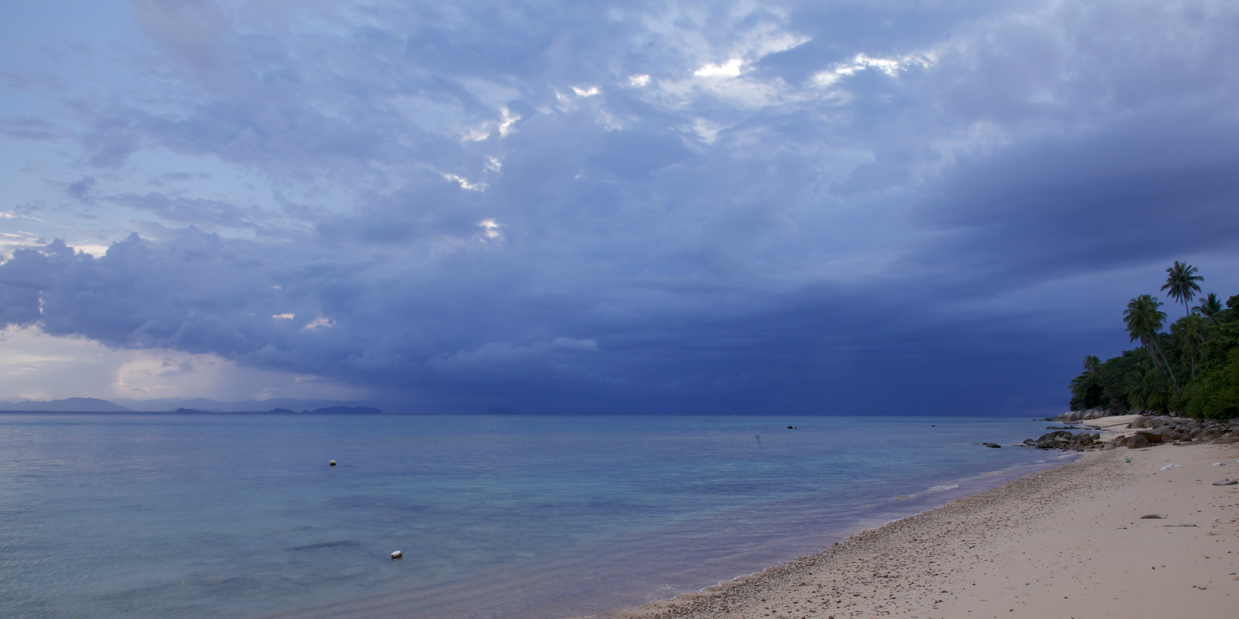 A cloud gathers over the ocean surrounding the Perhentian Islands. The annual rainy seasons give the reefs a break from tourism and help with coral reef conservation.