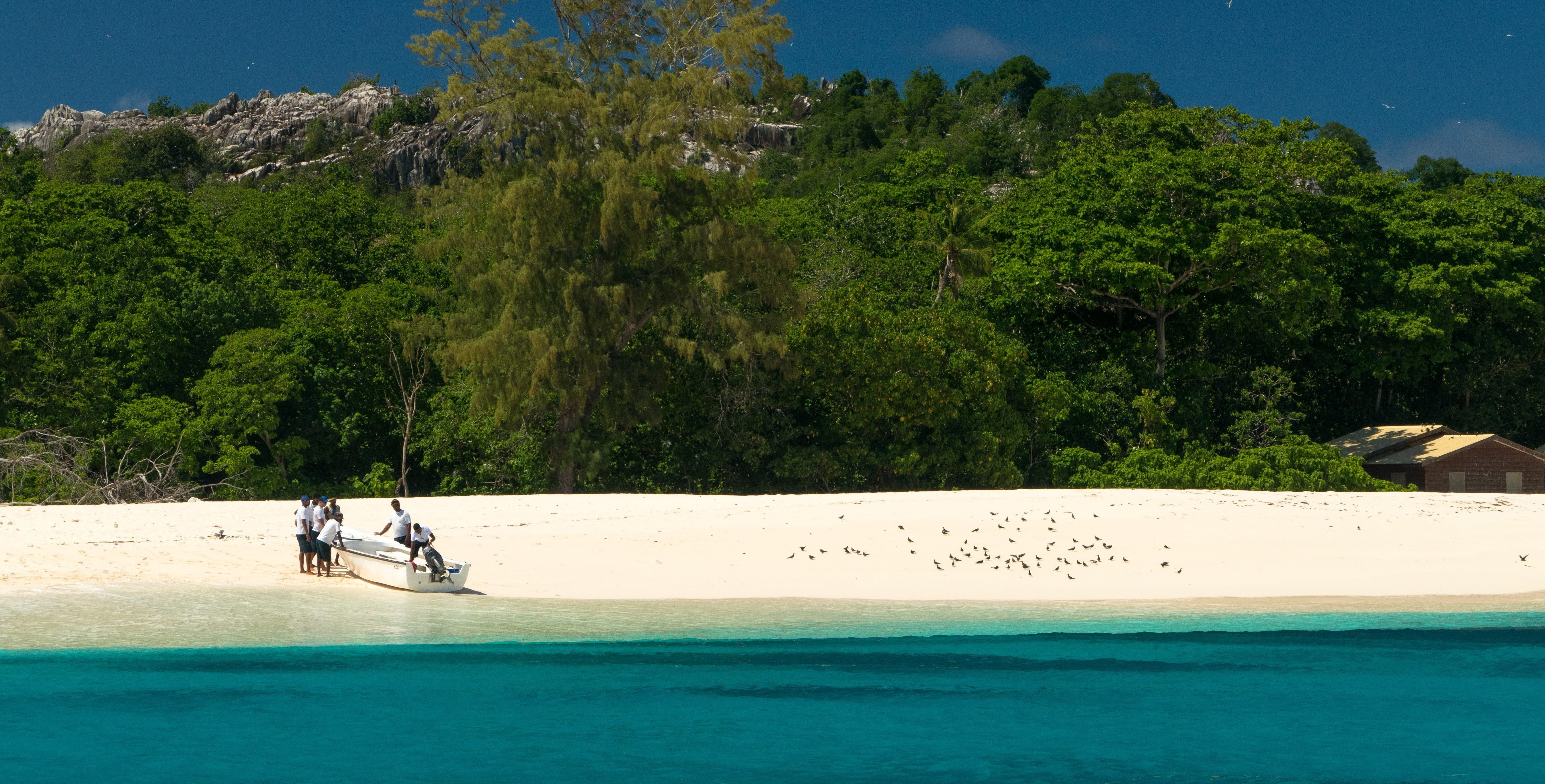 A small boat is pushed onto a beach on Bird Island in the Seychelles archipelago. This island is frequented by wildlife conservation officers and conservation volunteers.