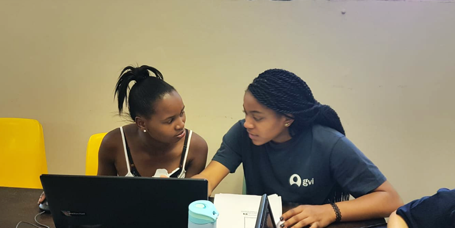 A women's empowerment volunteer provides mentorship in a computer skills class.