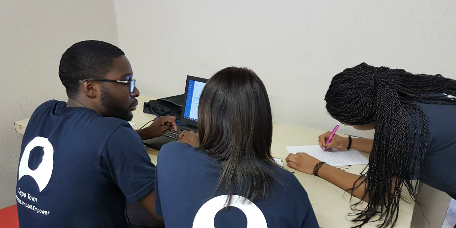 GVI participants plan lessons for the women's empowerment program on computer literacy.