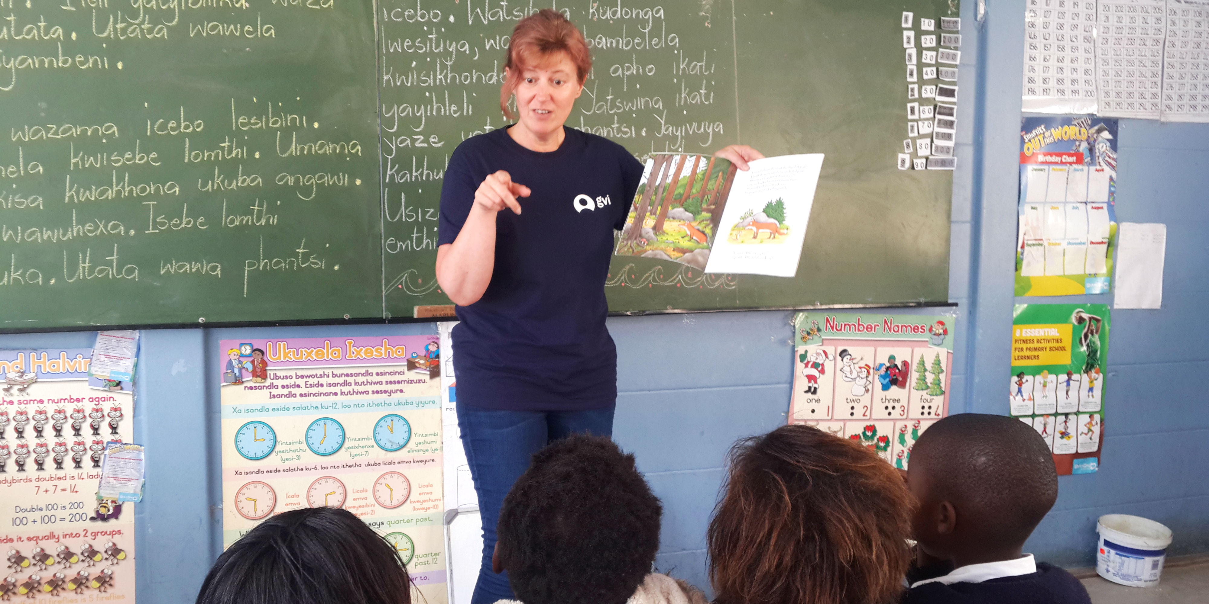 A GVI volunteer in South Africa reads a story to young learners. Education initiatives form an important part of promoting gender equality in education.