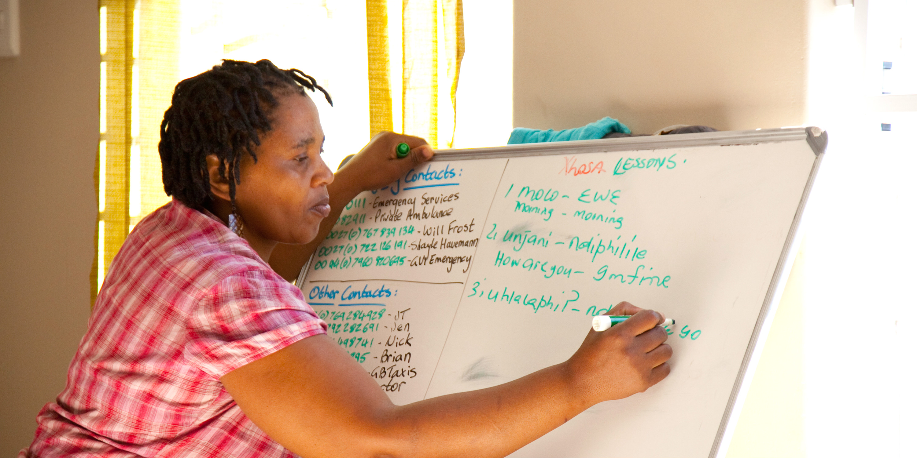 A women works on a language lesson with GVI, as part of a women's empowerment program.