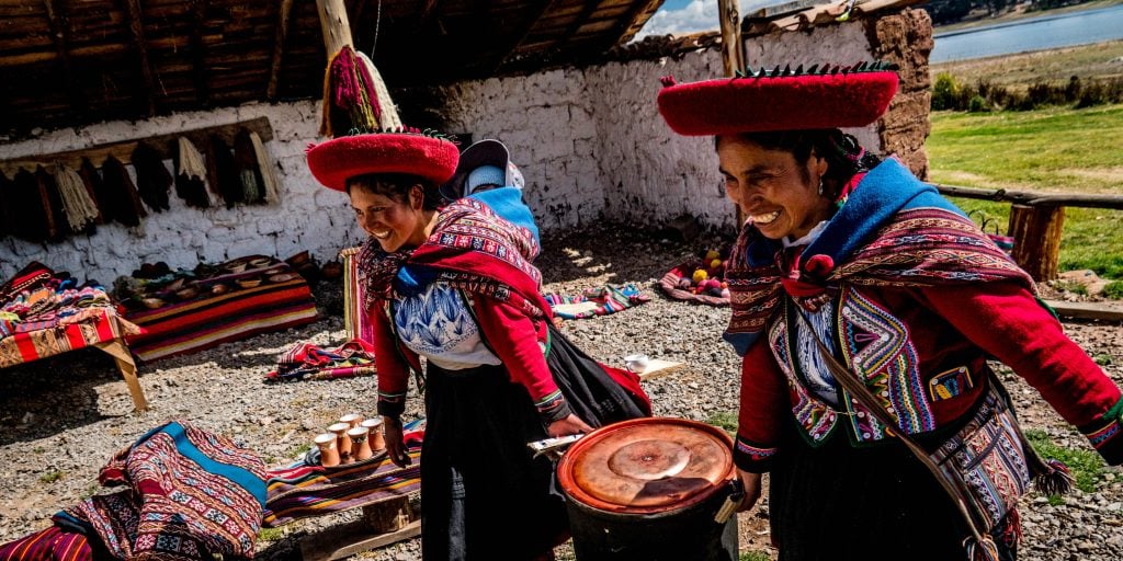 Two quechua people prepare a vat of dye for the traditional method of dyeing wool. 