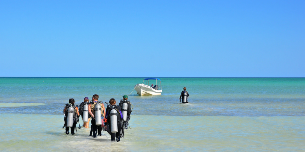 Participants on a research expedition heading out scuba diving.