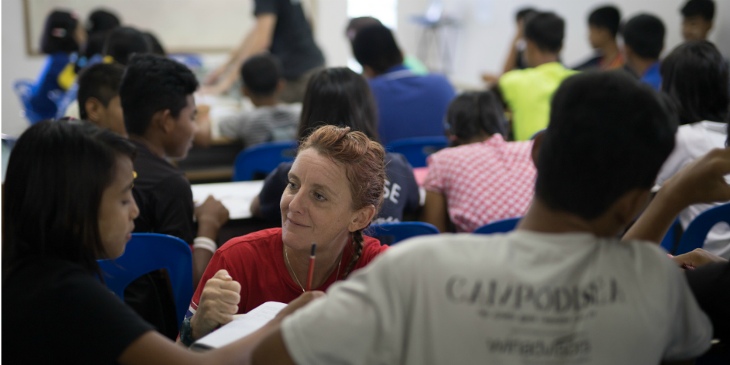 Volunteer assisting children in a lesson