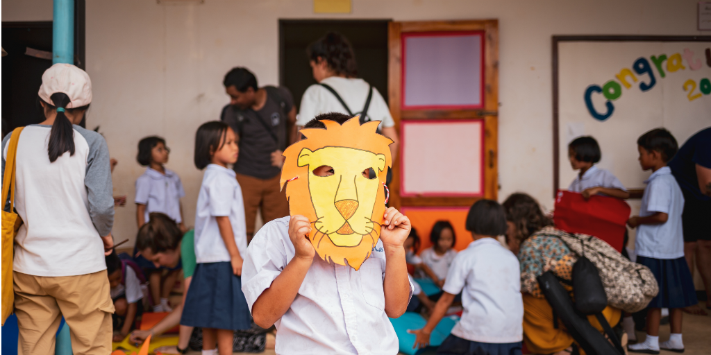 A child wearing a lion mask