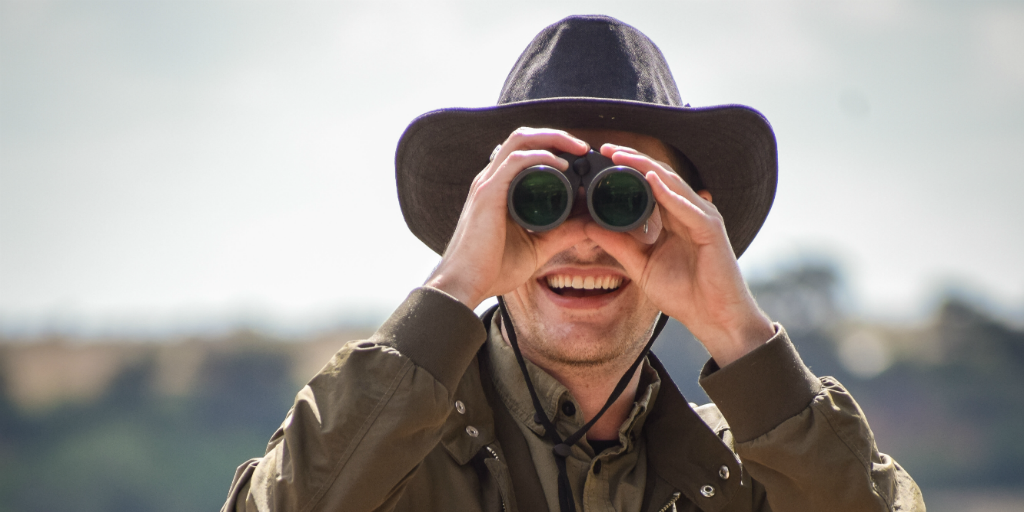 Wildlife volunteer looking into the distance with binoculars