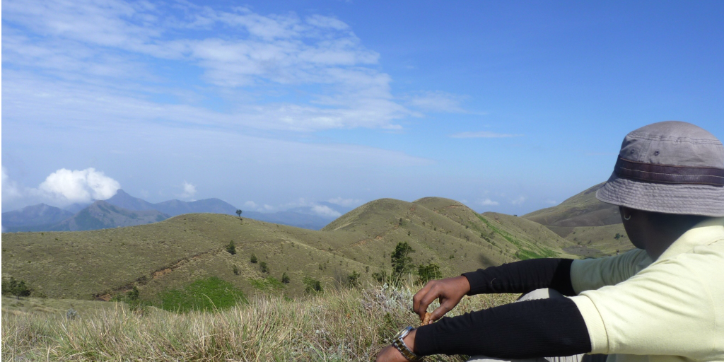 Volunteer sitting on a hill top looking at the view