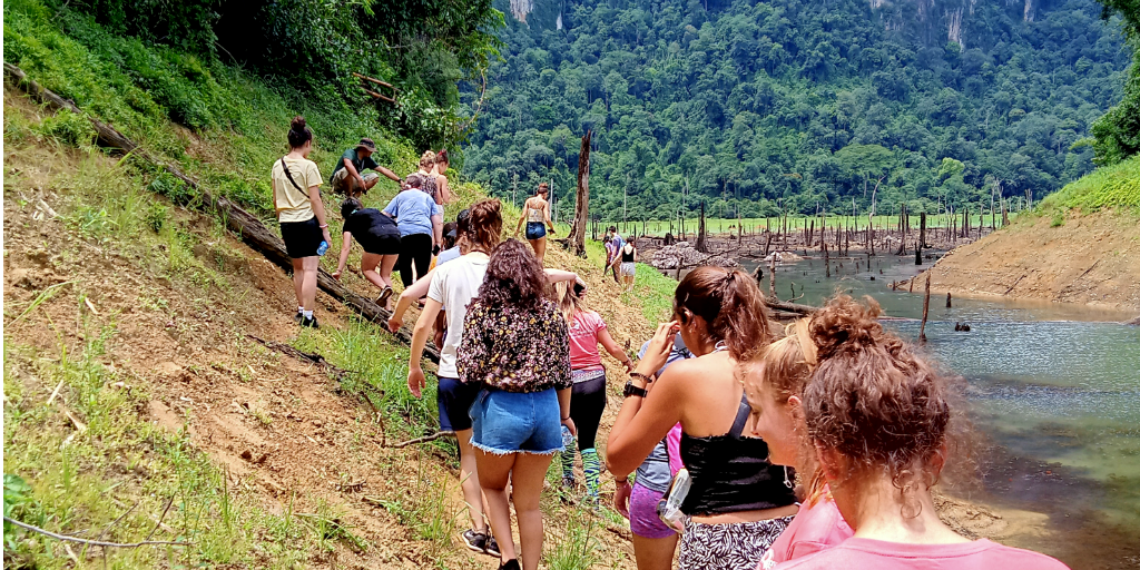 volunteers hiking alongside a river in Phang Nga