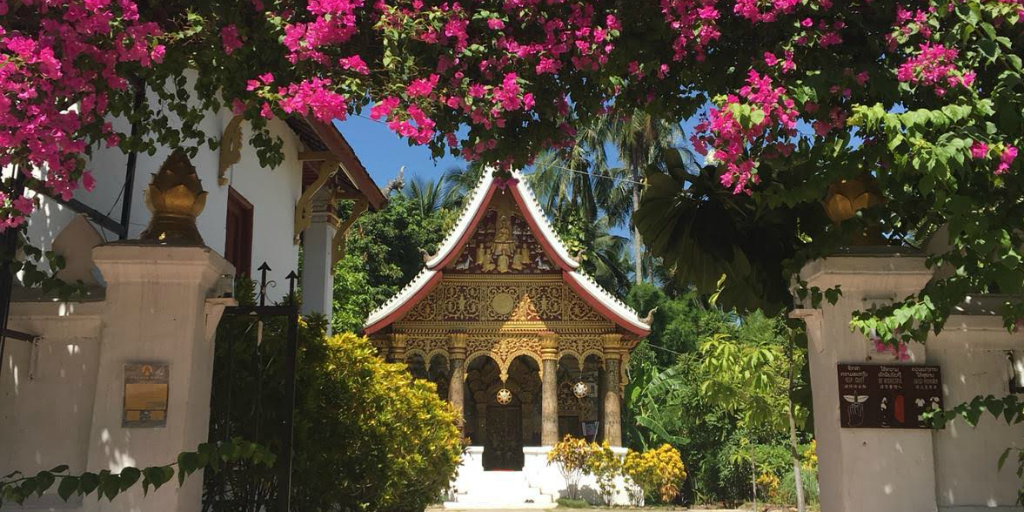 A temple beyond a bougainville archway in Thailand