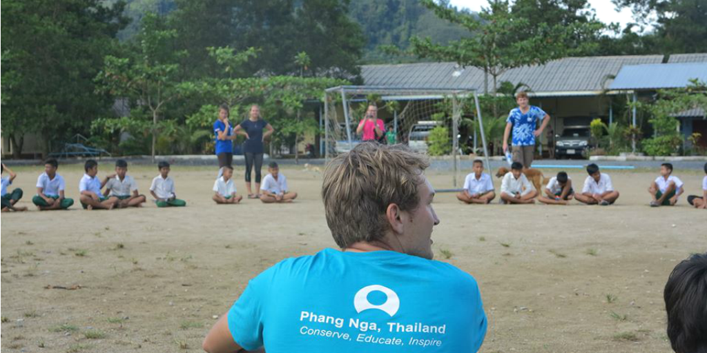 A GVI volunteer looking out over an outdoor class with children in Phang Nga, Thailand.