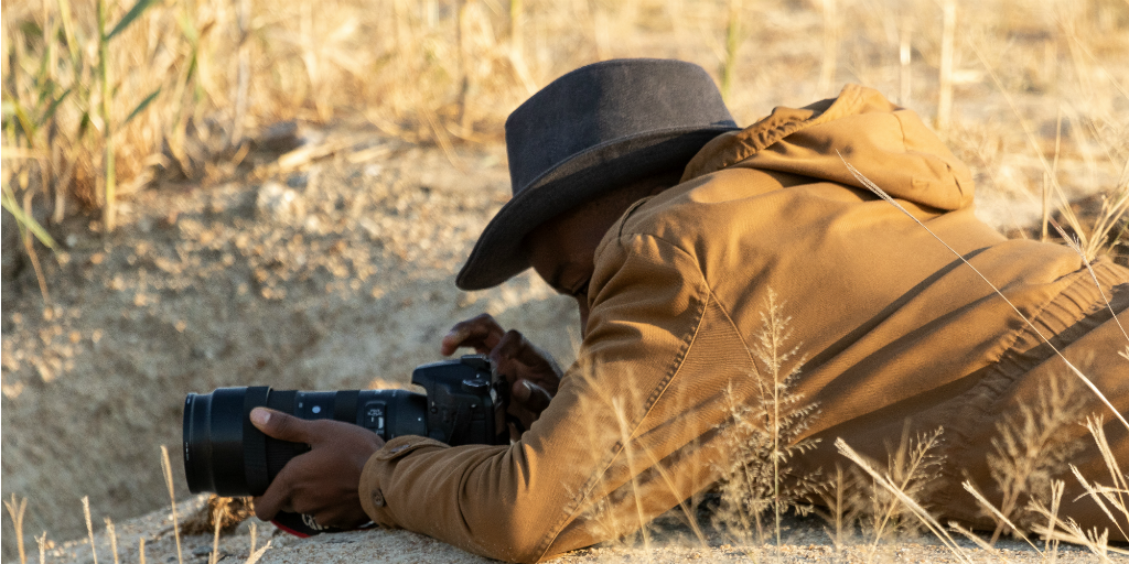 A GVI intern getting into position to take a wildlife photograph.