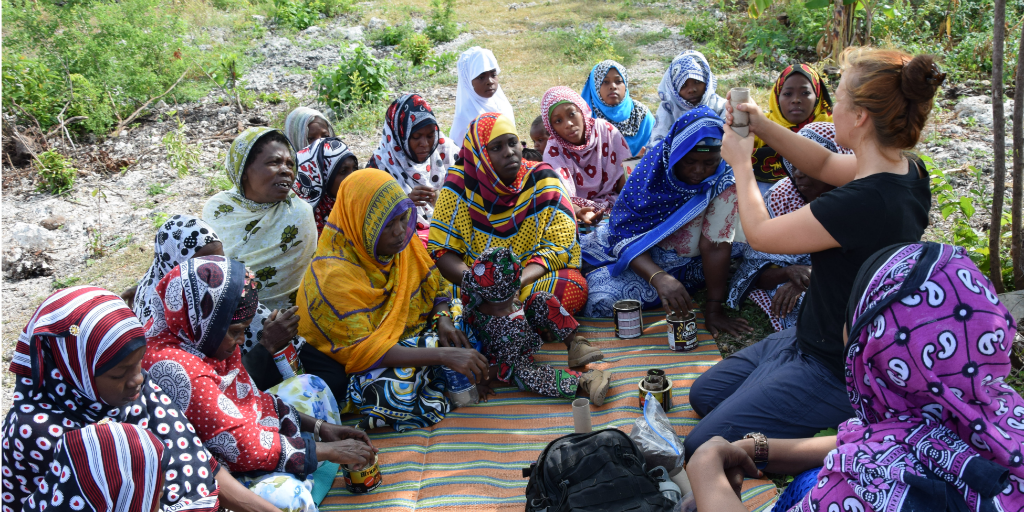 A volunteer doing a seed planting demonstration with women in Kilimanjaro.