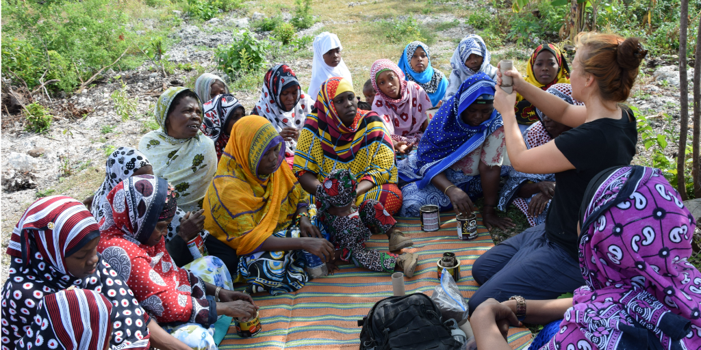 A volunteer working with a group of women.