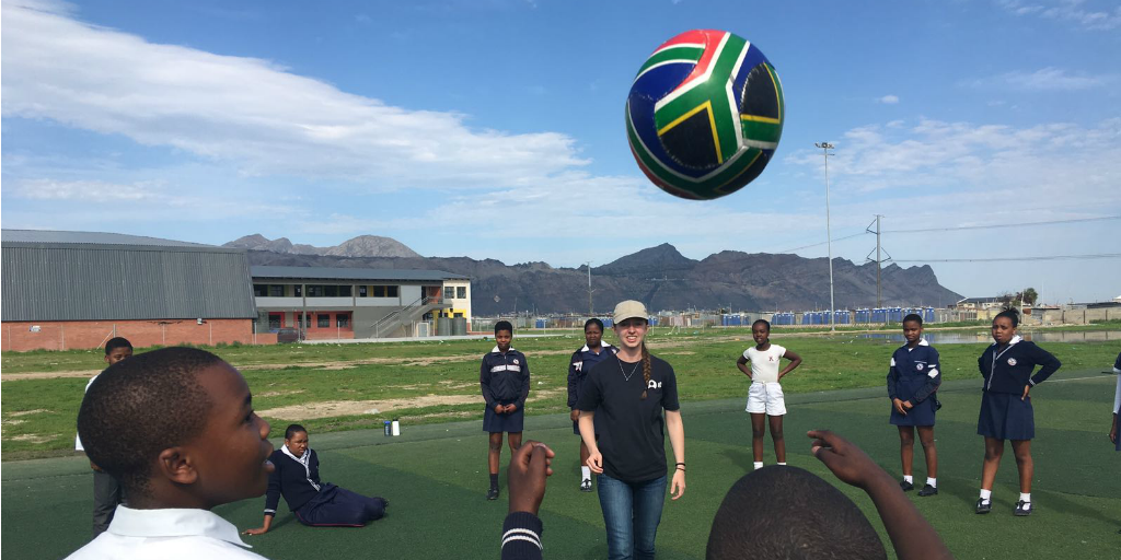 A volunteer playing soccer with students in Cape Town, South Africa.