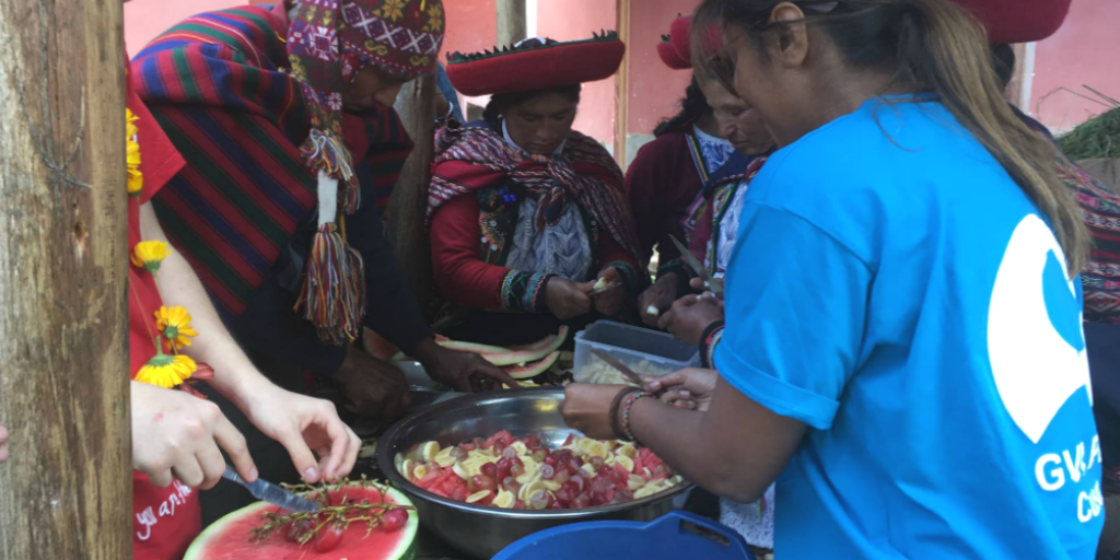 Community volunteers in Peru helping local Peruvian women cook
