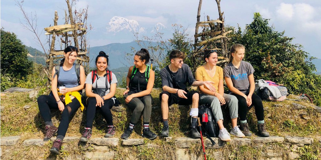 Hikers sitting on a rocky wall.