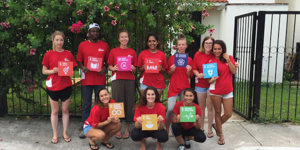 A group of volunteers holding up placards with the UN SDGs printed on them.